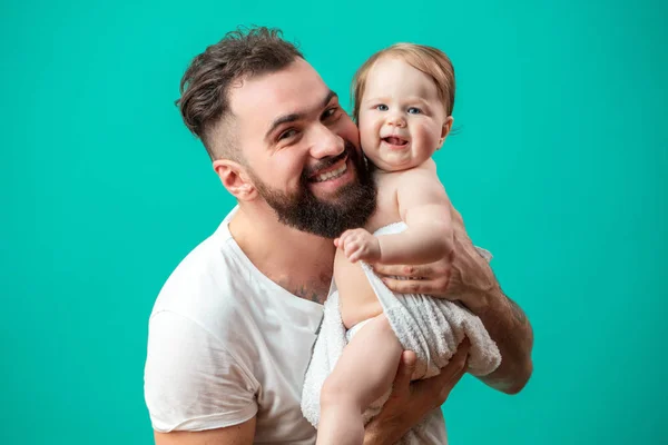 Грайливий батько носить свою усміхнену дитину на шиї на синьому фоні — стокове фото