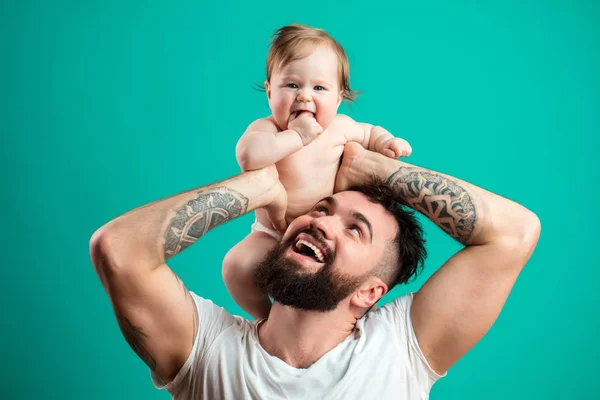 Pai feliz carregando sua filha bebê no pescoço isolado sobre fundo azul — Fotografia de Stock