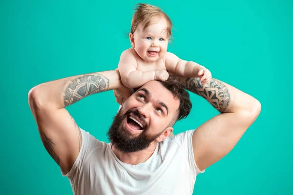 Gelukkig vader uitvoering van zijn dochtertje op nek geïsoleerd op blauwe achtergrond — Stockfoto