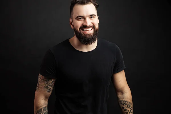 Portrait of handsome young man in casual t-shirt over black background. — Stock Photo, Image