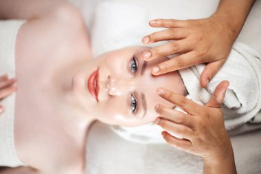 Çekici bir kadının yüksek açılı portresi kafa masajı yaptırıyor.