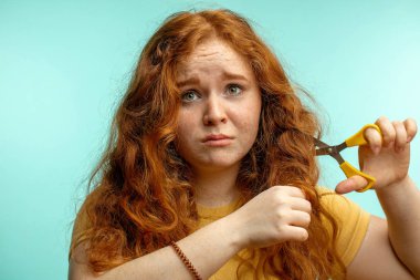 Üzgün ve saçları kurumuş, mavi yüzlü bir kadın.