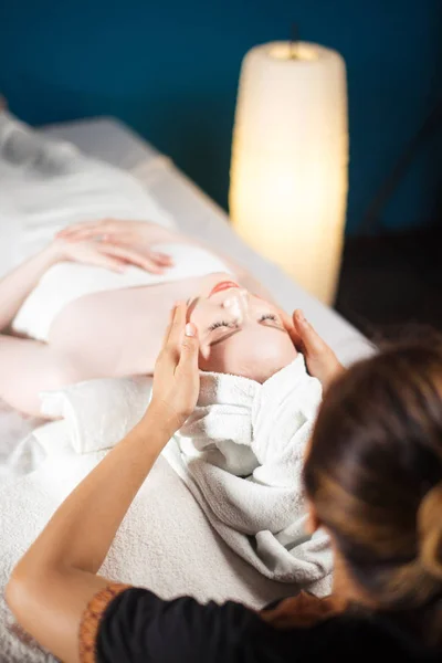 Healthful Leisure Time. Satisfied woman having face massage in spa complex.