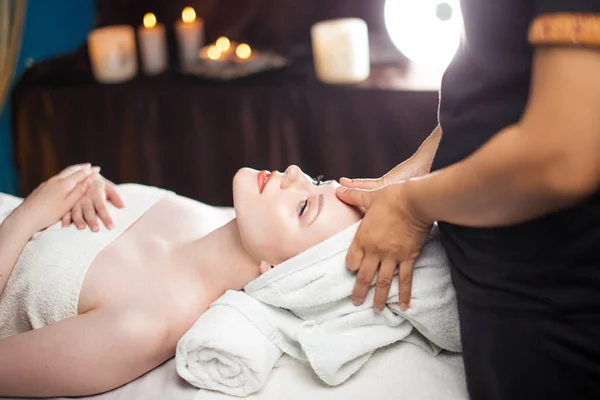 Jovem mulher bonita desfrutando de procedimento de massagem facial — Fotografia de Stock