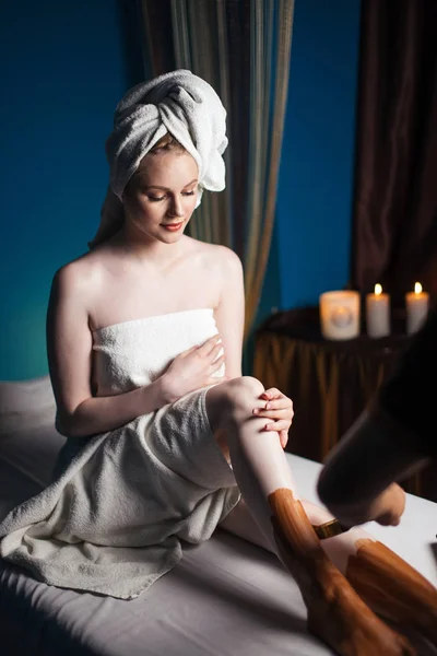 Vrouw met klei masker op benen ontspannen in spa salon — Stockfoto