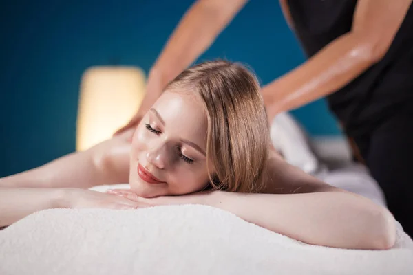 Jonge vrouw die plezier beleeft op massagebed, met gesloten ogen. Vrouw. Kuuroord. — Stockfoto