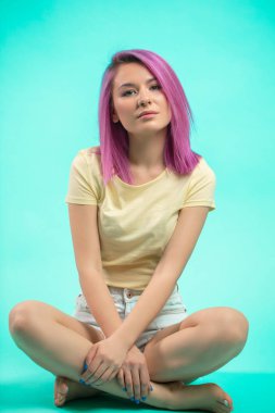 Stüdyoda oturan öğrenci. Katta oturan düz pembe saçlı Genç kız.