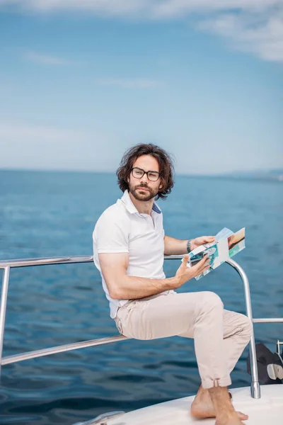 Молодой бородатый человек на роскошной яхте с великолепным видом на море. — стоковое фото