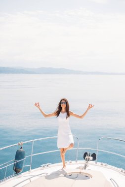 Lüks yelkenli teknede poz veren gözlüklü beyaz kadın model.