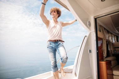 Genç yakışıklı adam tekneye binip yolculuğa çıkmaya hazırlanıyor.