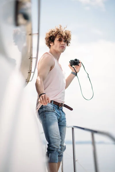 Junger gutaussehender Mann bereitet Boot auf eine Reise vor, steht auf dem Boot — Stockfoto