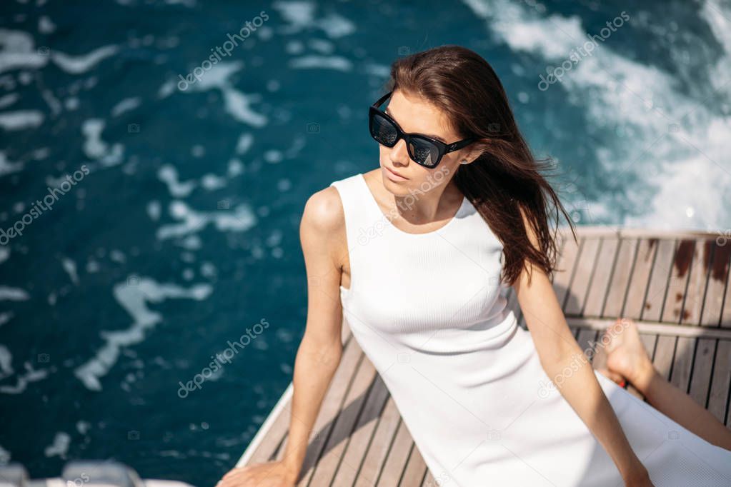 Young, attractive and rich woman having fotossesion on a luxury boat in sea