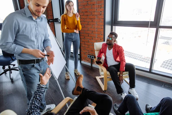 Gente multiétnica que planea estrategia de negocio con esquema en el rotafolio —  Fotos de Stock