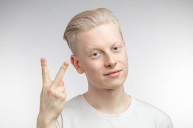 Pozitif sarışın adam, tamam işareti gösteriyor, her şeyin yolunda olduğunu gösteriyor.