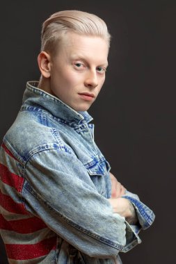 Kot jaket giyen yakışıklı sarışın Amerikalı adam siyah arka planda izole edilmiş.