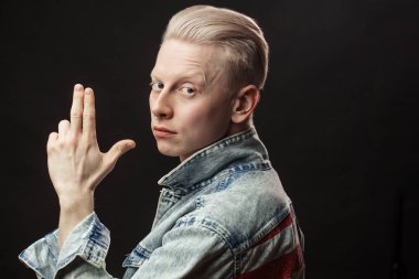 Kot jaket giyen yakışıklı sarışın Amerikalı adam siyah arka planda izole edilmiş.