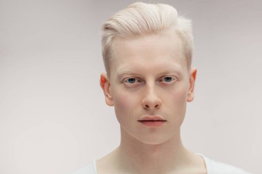 Beyazda izole edilmiş model erkek. Yakışıklı albino adam, yakın çekim..