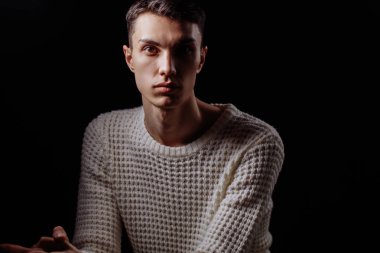 Beyaz tişört ve güneş gözlüğü takan yakışıklı bir erkek mankenin stüdyo fotoğrafı.