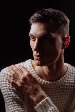 Beyaz tişört ve güneş gözlüğü takan yakışıklı bir erkek mankenin stüdyo fotoğrafı.