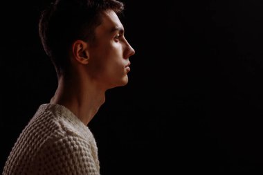 Beyaz tişört ve güneş gözlüğü takan yakışıklı bir erkek mankenin stüdyo fotoğrafı.