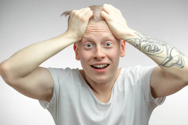 Emocionální přešťastný překvapený albínský model s odposlouchávanýma očima a otevřenými ústy. — Stock fotografie