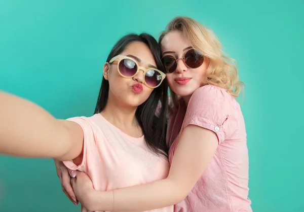 Diversos meninas em roupas casuais tiro selfie isolado no fundo azul. — Fotografia de Stock