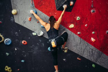 Güzel genç bir kadın yapay bir duvara doğru büyük bir adım atıyor.