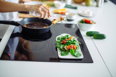 Domates, kiraz ve yeşillikle servis edilen tavuk kebabı.