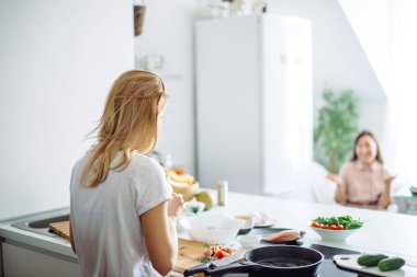 Genç ev hanımı mutfakta Linch 'e yemek yapıyor. arka plan