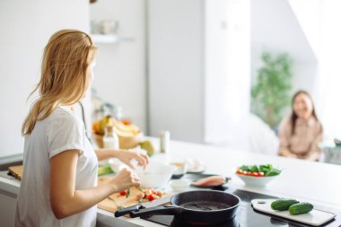 Genç ev hanımı mutfakta Linch 'e yemek yapıyor. arka plan