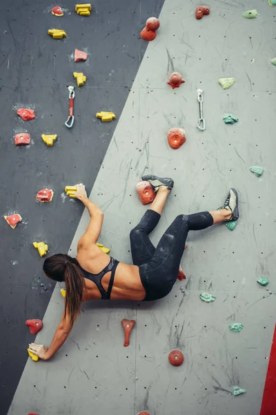 Hermosa joven mujer dando un gran paso por una pared artificial —  Fotos de Stock