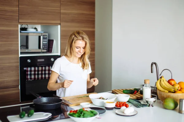 Angenehme junge Frau bereitet Abendessen in einem Küchenkonzept Kochen, kulinarische — Stockfoto