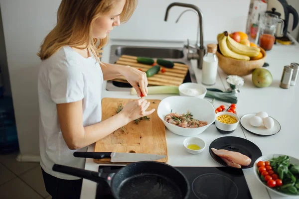 Frau macht in Küche Spieße aus Fleisch und Gemüse auf Schneidebrett — Stockfoto