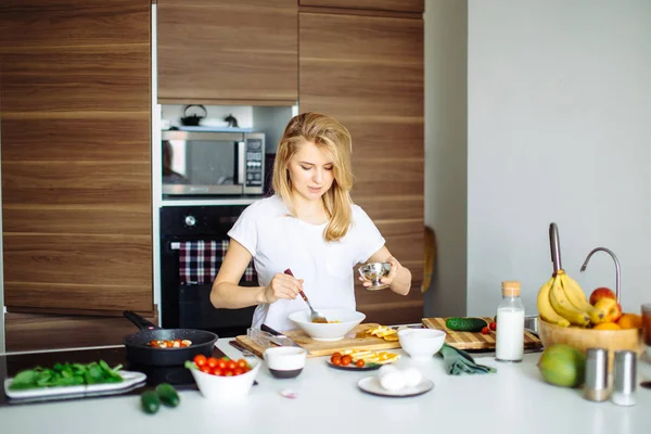 Mujer mezclando deliciosos ingredientes de ensalada de superalimentos con cucharas de madera en la cocina — Foto de Stock