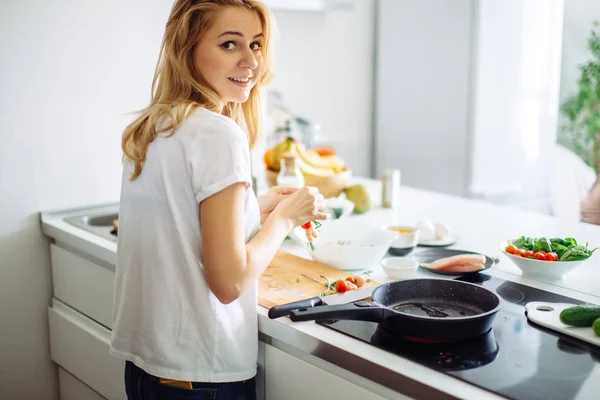 Jovem dona de casa fazendo refeição para linch na cozinha. vista traseira — Fotografia de Stock