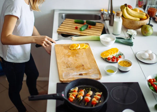 Vista superior de mujer irreconocible cortando naranjas frescas con cuchillo. — Foto de Stock