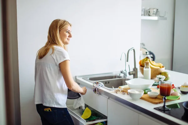Junge Frau putzt Geschirr in Küche — Stockfoto