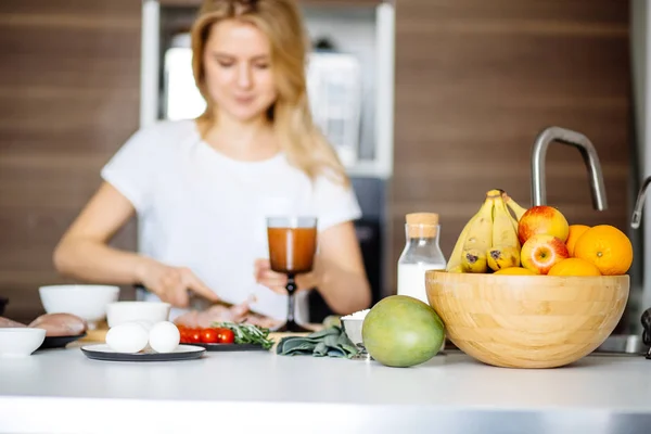 Kvinna skära chiken kött på ett köksbord med en stor Chef kniv — Stockfoto