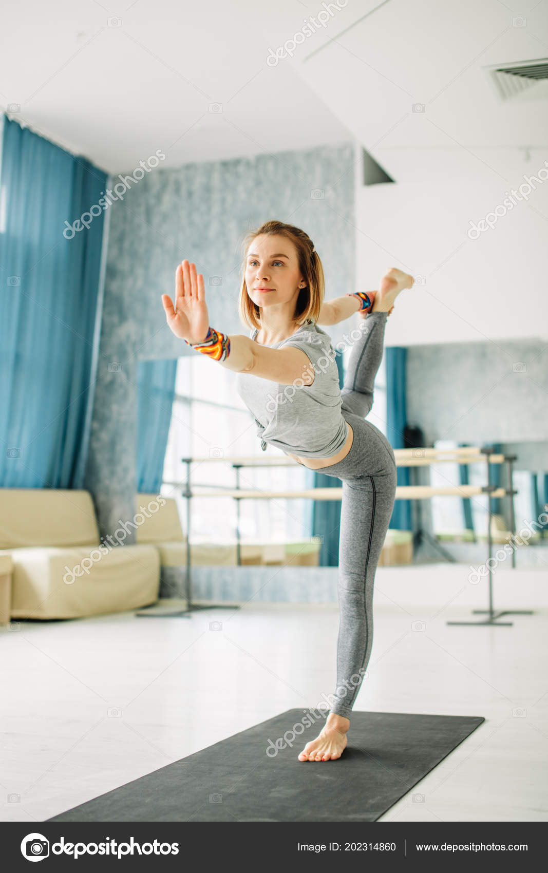 Young fit woman doing a yoga pose standing with one leg raised up. 37 Young fit woman doing a yoga pose standing with one leg raised up. 37
