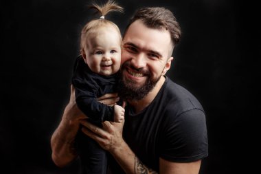 Siyah arka plan üzerine bebek ile genç atletik baba