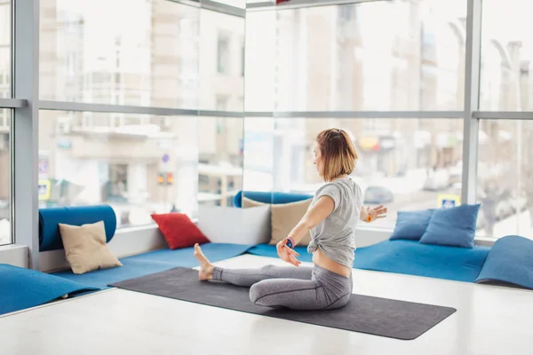 Sportos lány ül félig ura a halak, Ardha Matsyendrasana pózol. — Stock Fotó