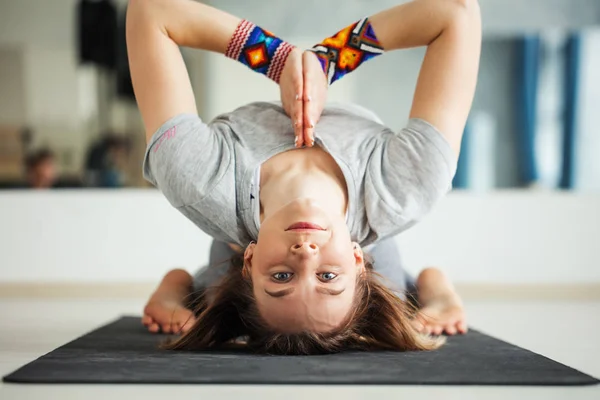 Adult woman in supta virasana yoga position in studio — Stock Photo, Image