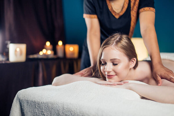 Женщина получает массаж тела в спа-салоне