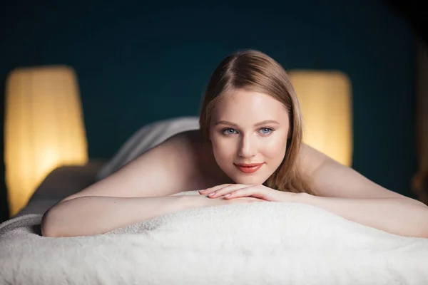 Young, beautiful woman in spa salon lying on the coach waiting for massage.