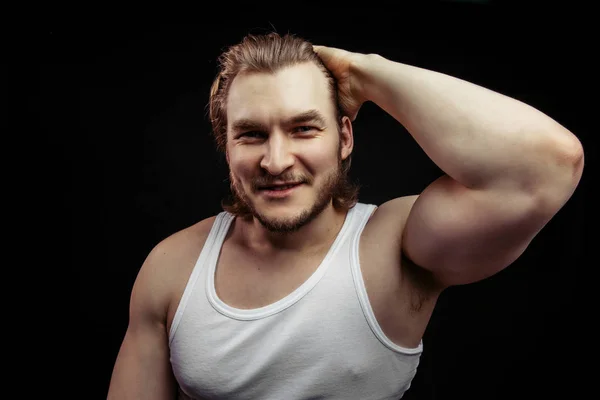 Retrato de um belo jovem de cabelos bonitos mostrando e seu grande bíceps — Fotografia de Stock
