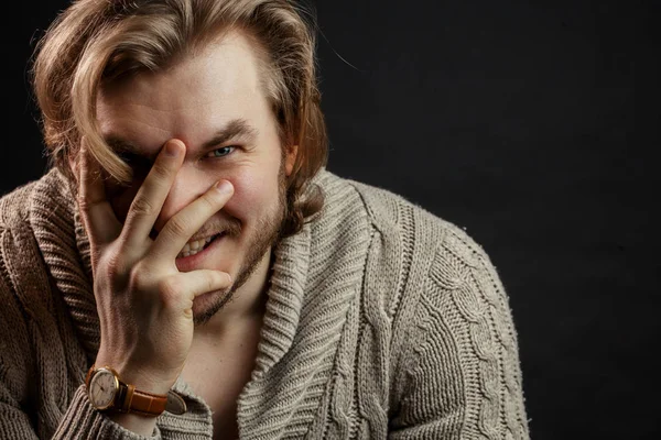 Ritratto ravvicinato di uomo brutale che ride e chiude il viso con la mano — Foto Stock