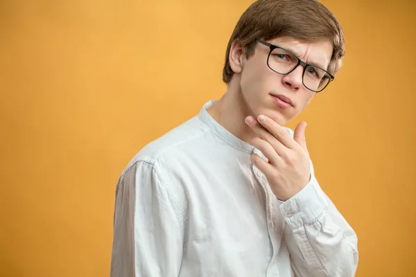 Réfléchi jeune homme isolé sur le fond jaune — Photo