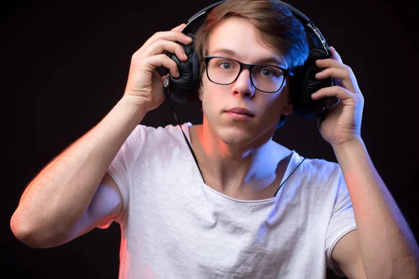 Primer plano retrato de hombre joven comprobando el sonido en los auriculares — Foto de Stock