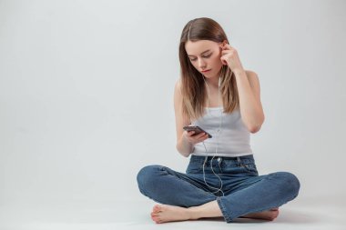 smartphone ile kulaklık kullanarak güzel kız öğrenci portresi kapatın