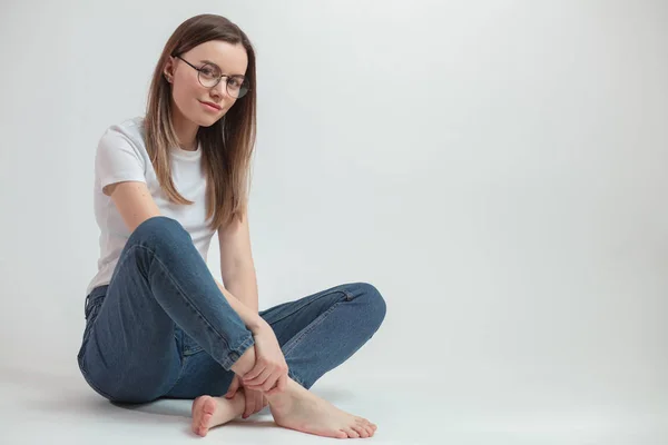 Slimme jonge vrouw zitten met gekruiste benen — Stockfoto